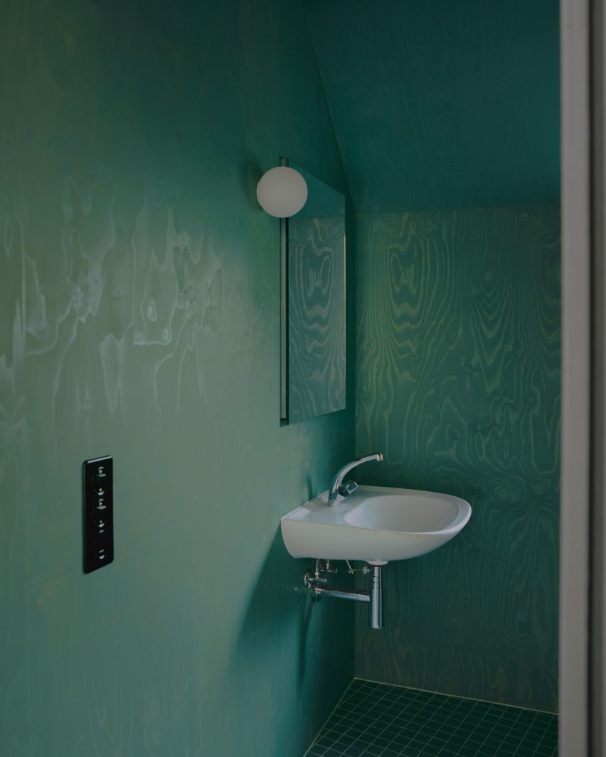 Green plywood walls inside bathroom