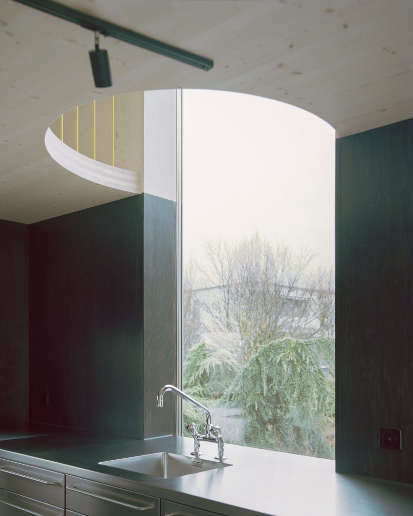 Kitchen sink with semi-circular cut-out in plywood mezzanine above