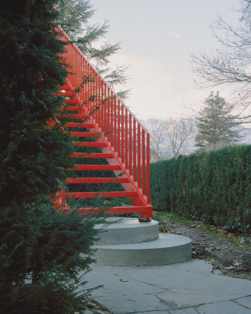 Red steel staircase resting on stones