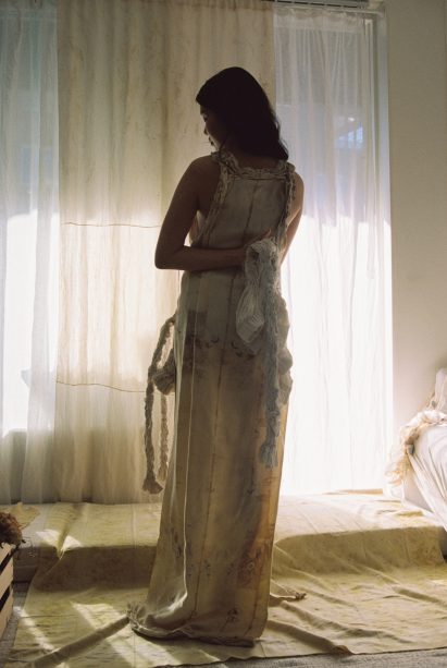 a photograph of a person wearing a garment in tones of beige and white