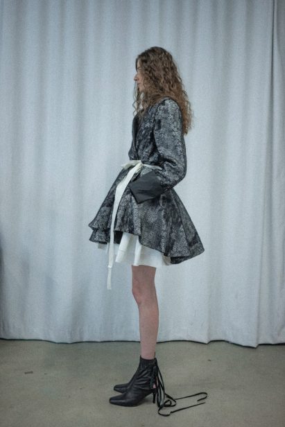 a photograph of a person modelling clothing in tones of black and white