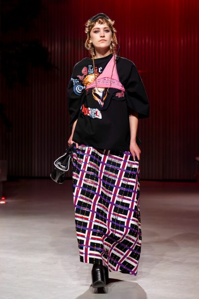 a photograph of a person wearing garments in tones of black, pink, blue and white