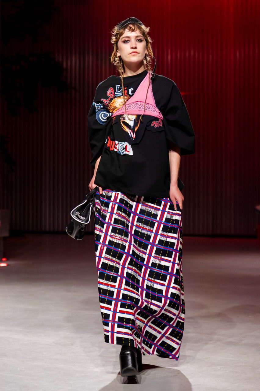 a photograph of a person wearing garments in tones of black, pink, blue and white