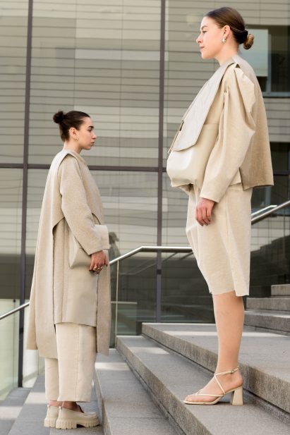 a photograph of two models wearing beige garments