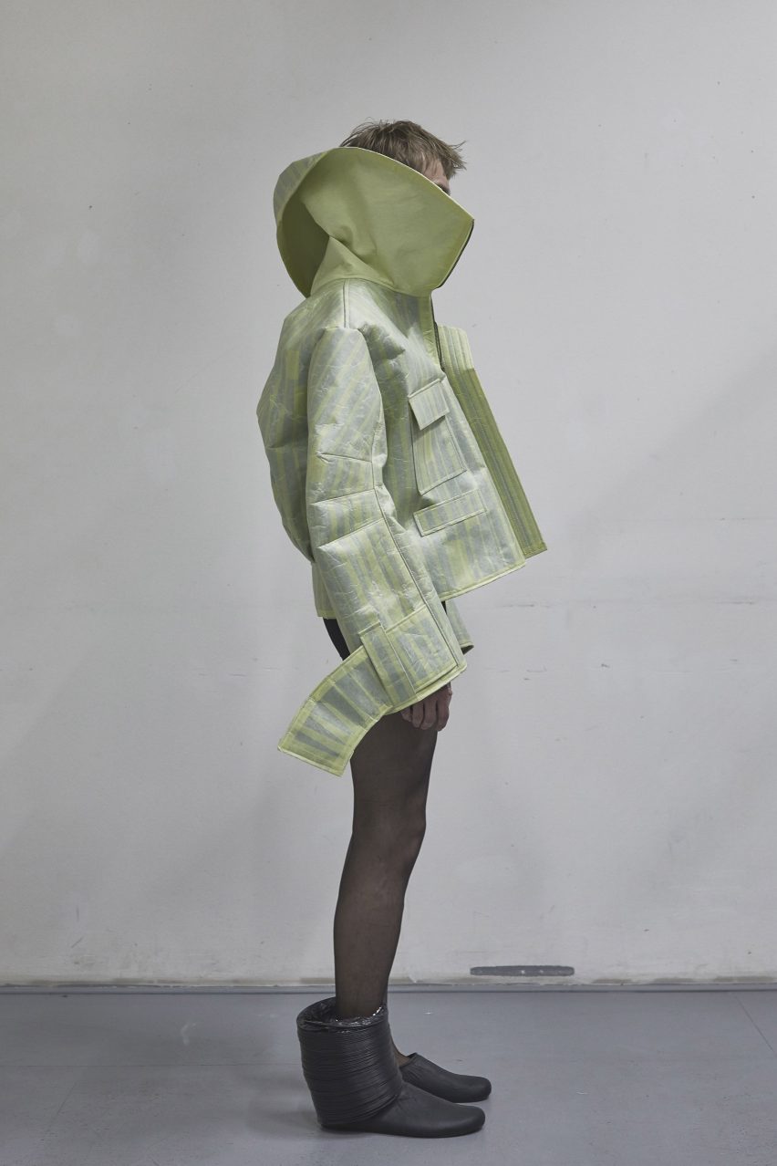 a photograph of a person modelling a green garment