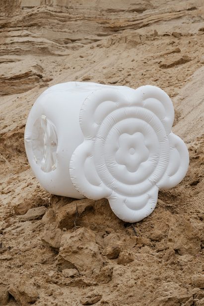 a photograph of an inflatable white object on sand