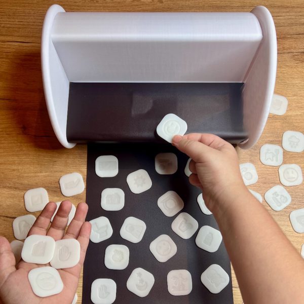 a person's hands holding white square tokens