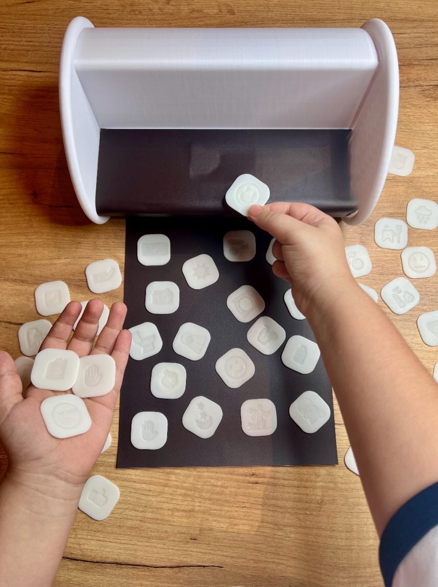 a person's hands holding white square tokens