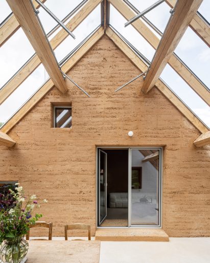 Rammed-earth wall within winter garden by Hé!