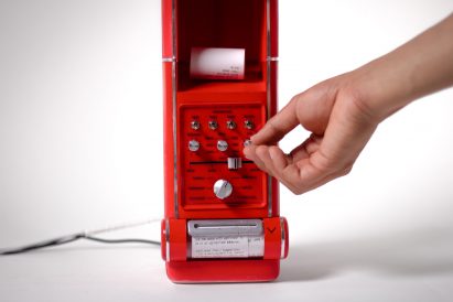 Hand turning dials on a red machine