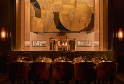 Open kitchen below a custom, art deco-influenced metal hood