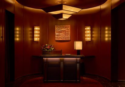 Restaurant lobby with low lighting and red-panelled walls