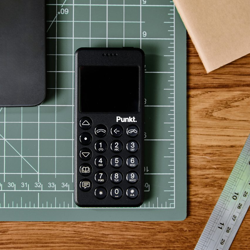 Photo of the Punkt MP02 in black flat laid on a desk besides measuring tools