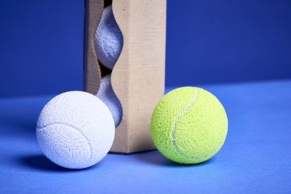 a photograph of two tennis balls and a box behind them