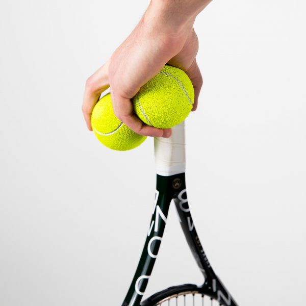 Hand holding tennis balls and tennis racket