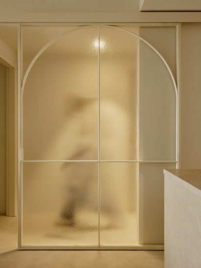 A figure walking behind a translucent glass door