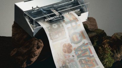 a photograph of a printer printing a sheet of white paper with brown and beige images and text on it