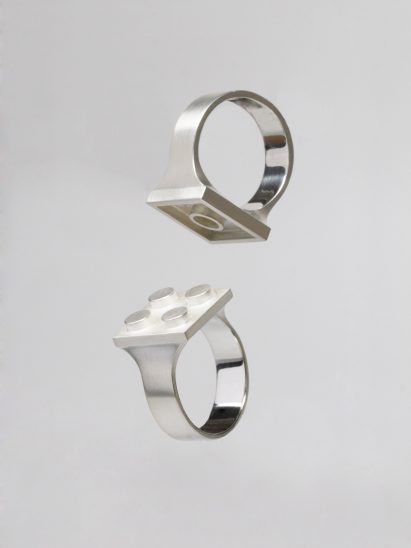 Silver rings with central plate shaped like Lego tile