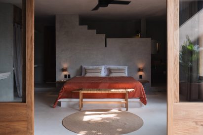 Guest room minimally furnished with characterful objects and textiles