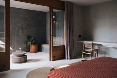 Covered balcony featuring built-in seating, stone tables and terracotta plant pots
