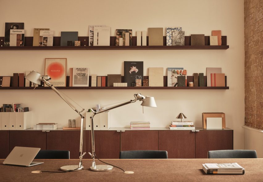 Neutral workspace with brown shelving and cupboards and metal adjustable desk lamps