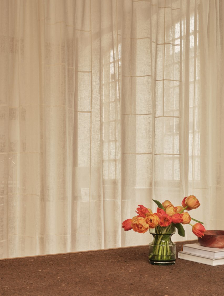 Neutral workspace with large factory windows and sheer curtain