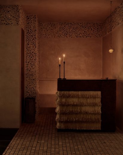 Restaurant host stand wrapped in layers of woven fringe 