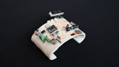 Photo of a WoolTech circuit board moulded into a rounded, cuff-like shape