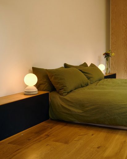 Two Wake sleep lamps besides a green coloured bed