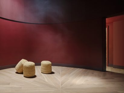 Room with sumac red walls and radial-patterned wood flooring