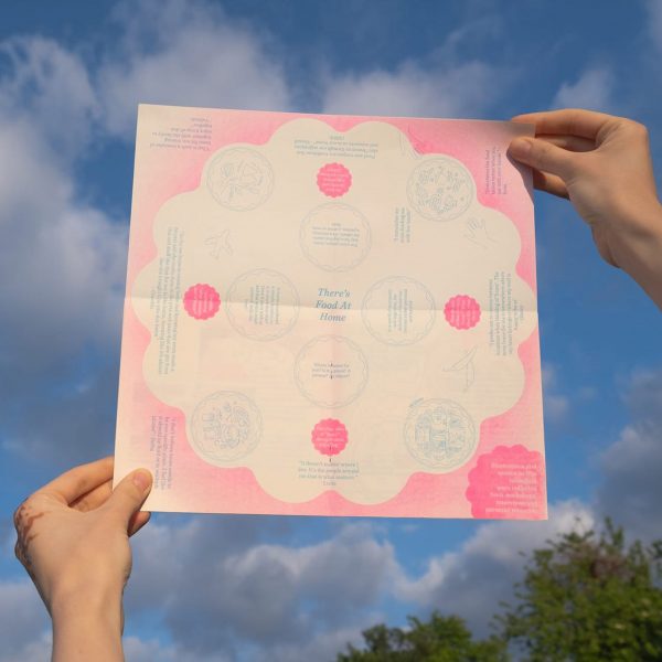 a photograph of a person holding up a poster in tones of pink and white