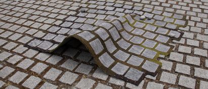 a photograph of a camouflage rug on a cobbled street