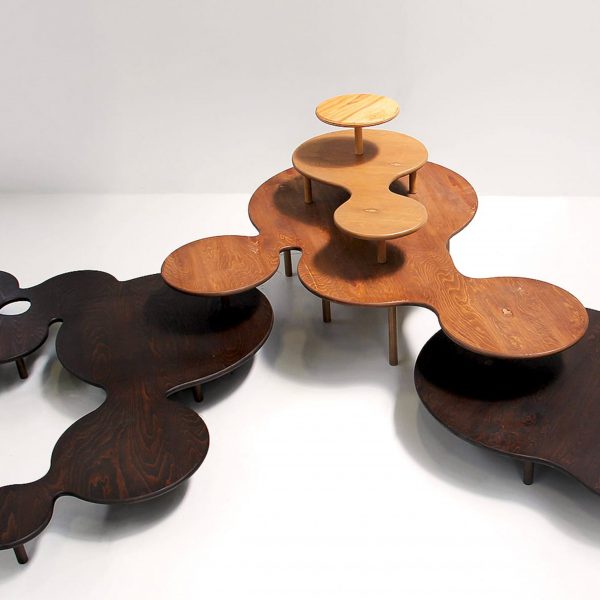 a photograph of circular, abstract-shaped tables in tones of brown