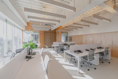 An open-plan workspace bathed in natural light and featuring white furniture