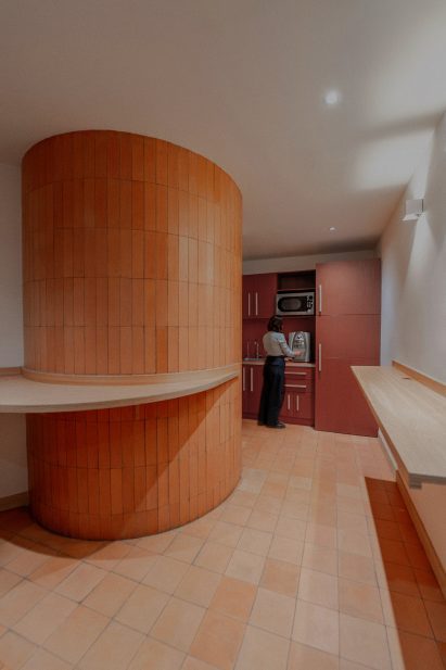 A large column clad in terracotta tiles to match the kitchen floor
