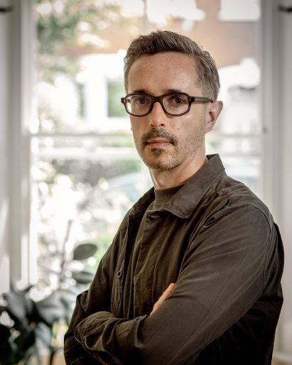 a photograph of a person in a brown shirt