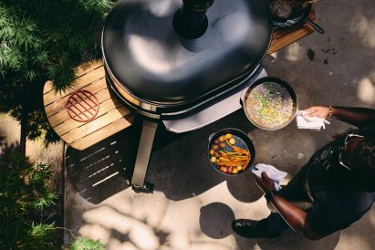 Person putting pans into an outdoor oven