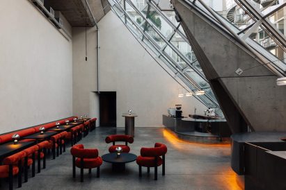 Cafe with burnt orange seating and black furniture within a triangular building
