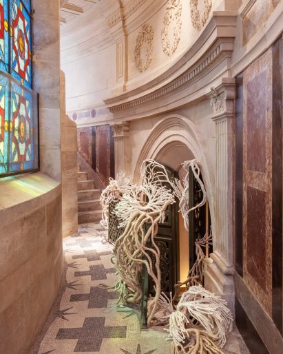 Corals of Liberty installation coming through a door in Paris's July column
