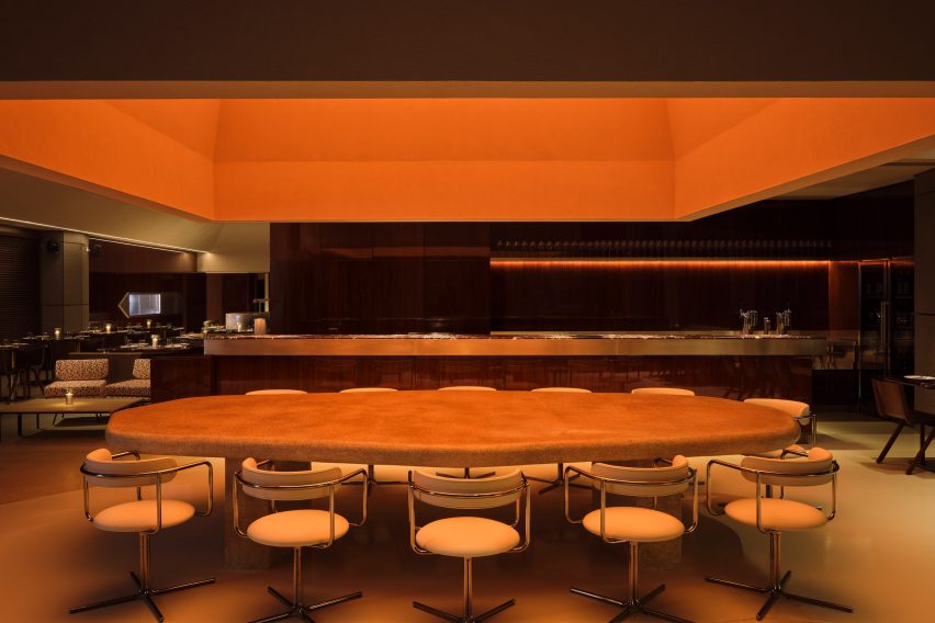 Geometric ceiling feature and light above shared dining table