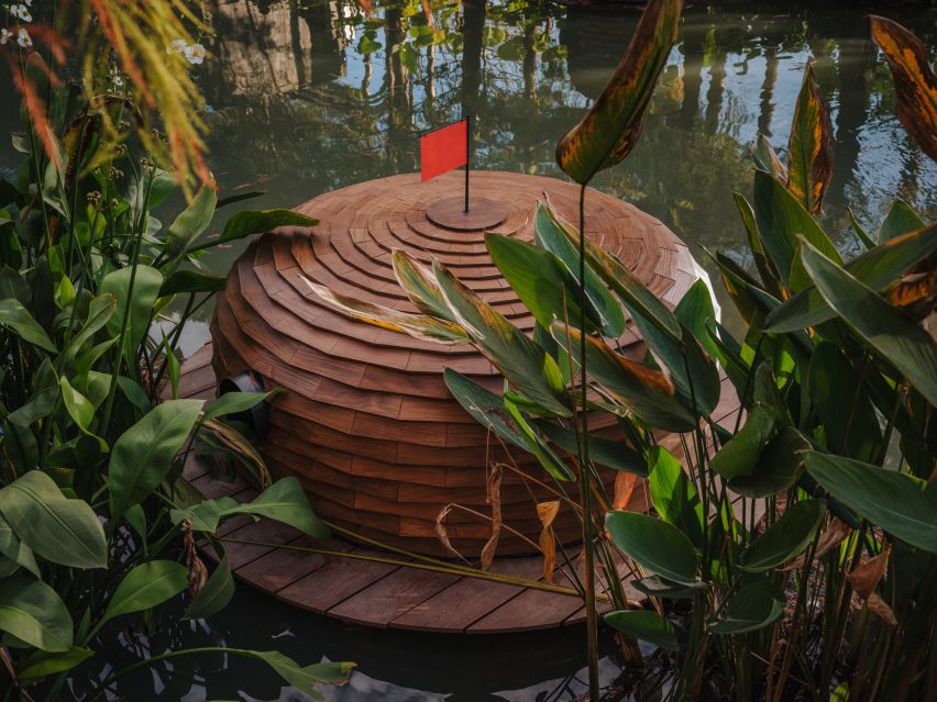 Wood pinecone-shaped duck shelter with red flag