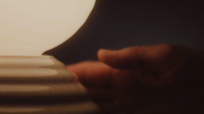 Hand touching a ceramic base