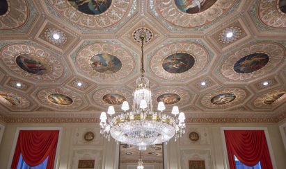 Grand room with an ornate ceiling and large chandelier