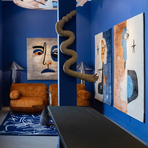 Photo of a living space with blue walls and rust-coloured art and sofa
