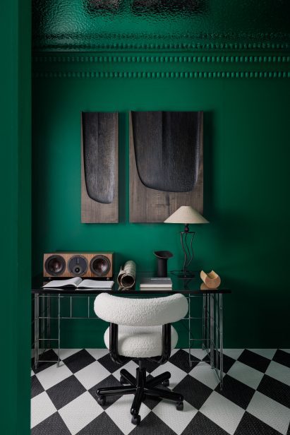 Desk and white chair next to an emerald green wall