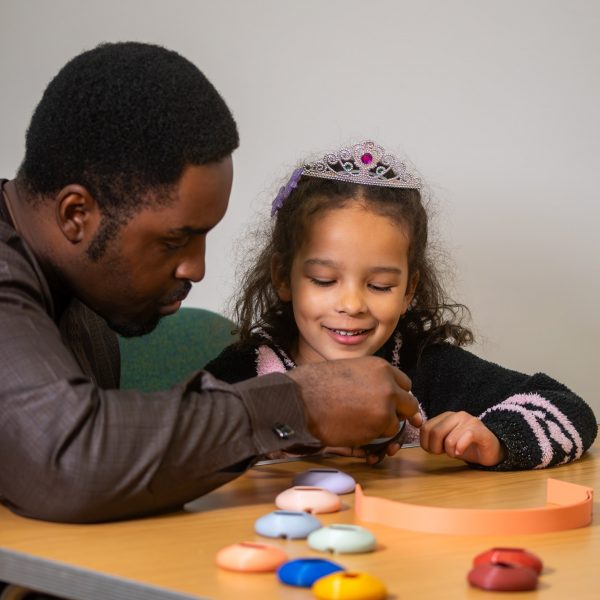 An adult and child work together to built the headphones