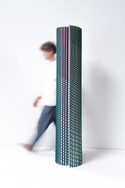 A person behing the textile-based room divider in blue