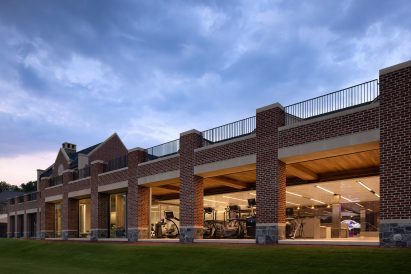 Exterior of a brick building with columns in front of a long glass wall
