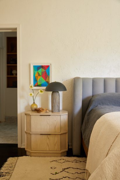 Bedside table area with stripy lamp on table