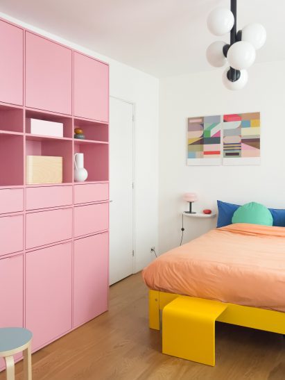 Bedroom with pink storage unit and yellow bed frame
